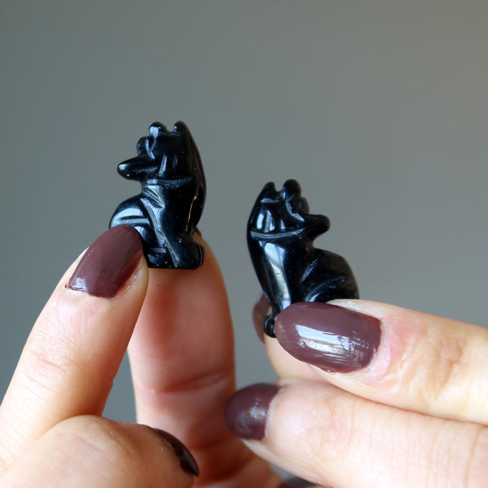 holding 1" Black Obsidian Wolves in each hand