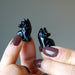 holding 1" Black Obsidian Wolves in each hand