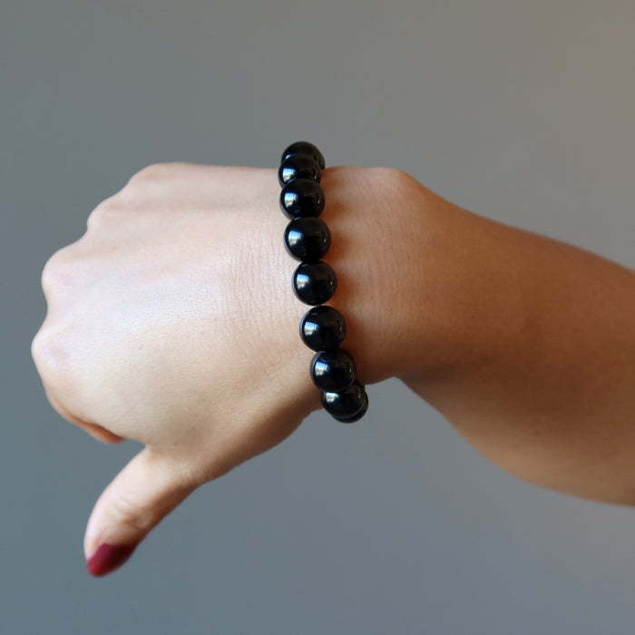 hand wearing black onyx bracelet
