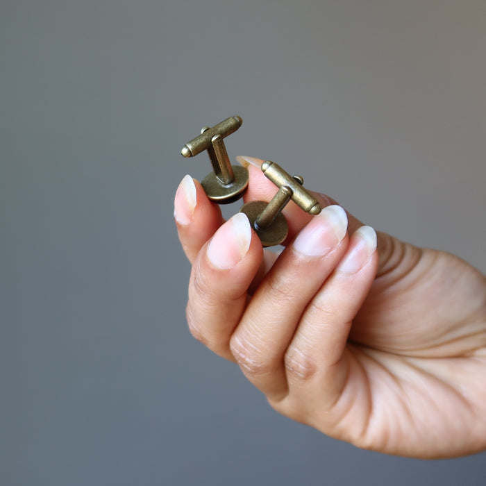hands holding  black onyx cufflinks