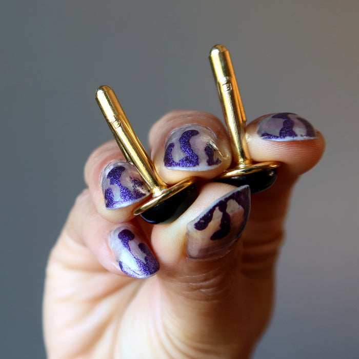 hands holding open black onyx cufflinks