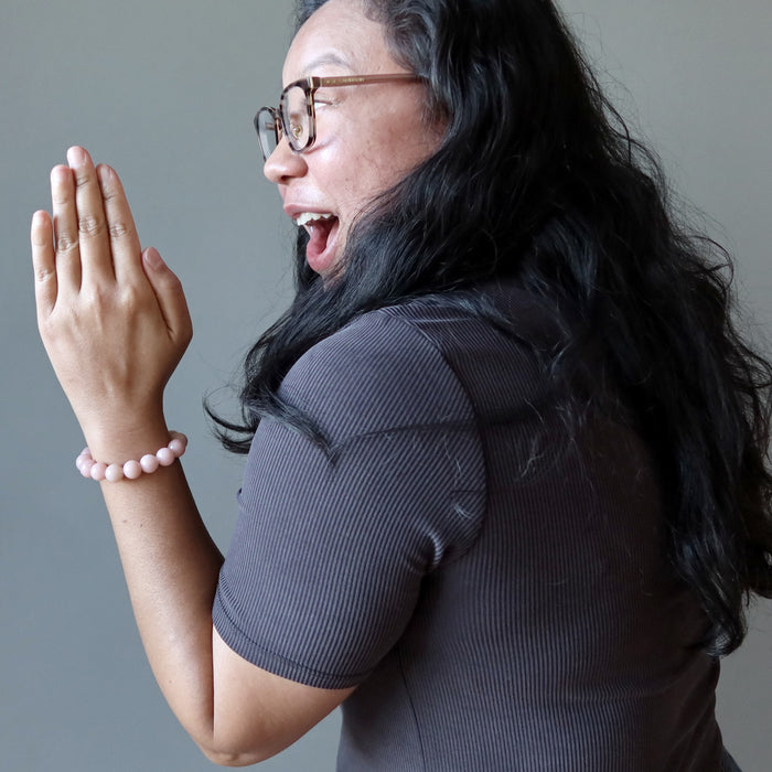 lady excitedly looking at the pink opal bracelet on her wrist