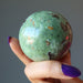 hand holding green opal sphere 