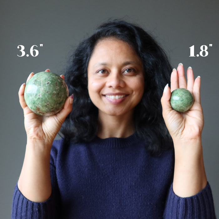 sheila of satin crystals holding two green opal spheres