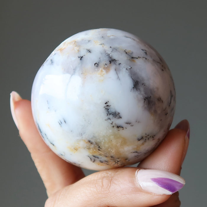 hand holding white opal sphere