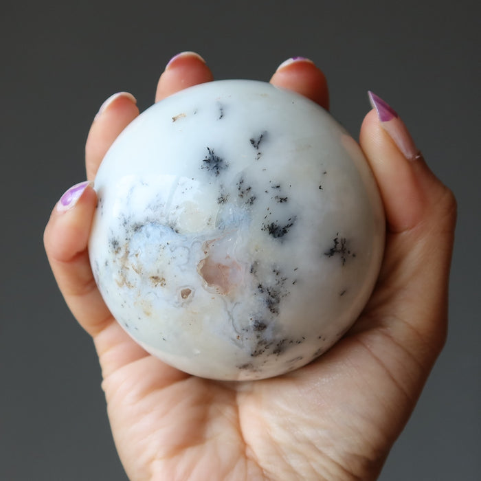 hand holding white opal sphere