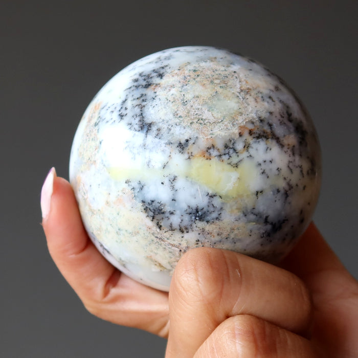 hand holding white opal sphere