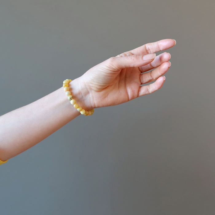 hand wearing a round yellow opal beaded stretch bracelet