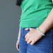 green prehnite crystal bracelet on the wrist of a lady holding her hands to her jean pocket