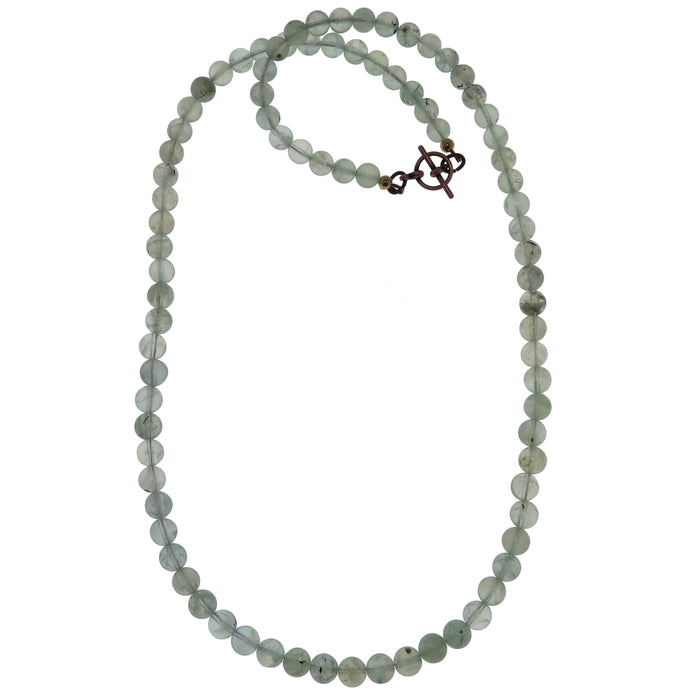 A beaded Prehnite necklace in grassy green color with black Tourmaline inclusions, displayed on a white background.