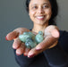 woman holding prehnite tumbled stones