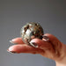 hand holding gold pyrite geode sphere