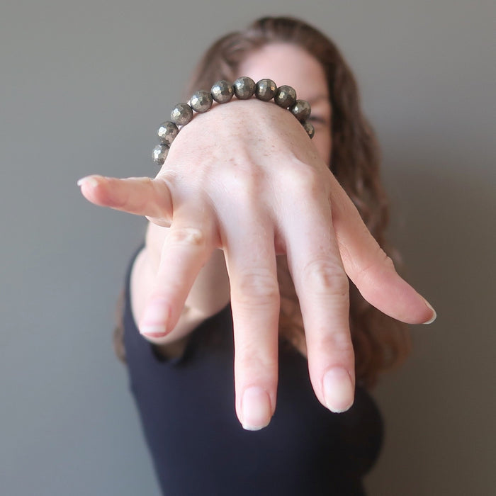 a round beaded gold pyrite bracelet on a model's wrist