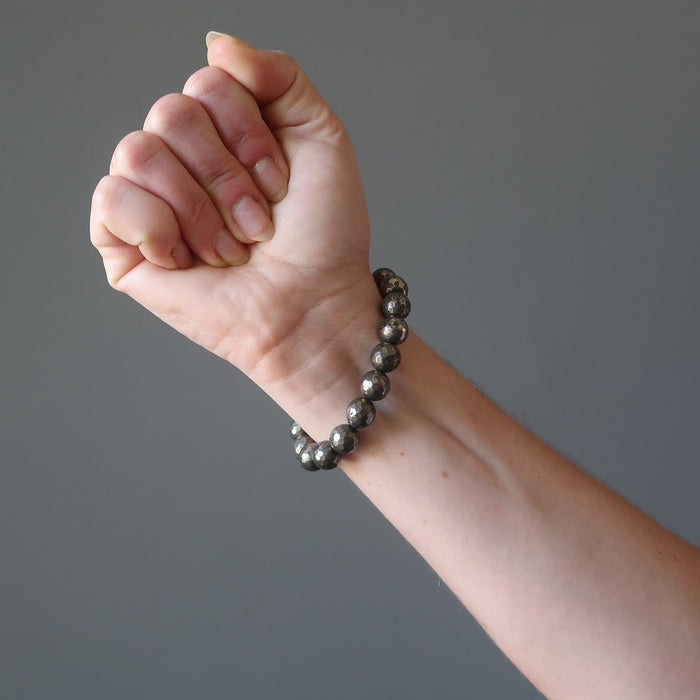 a round beaded gold pyrite bracelet on a model's wrist