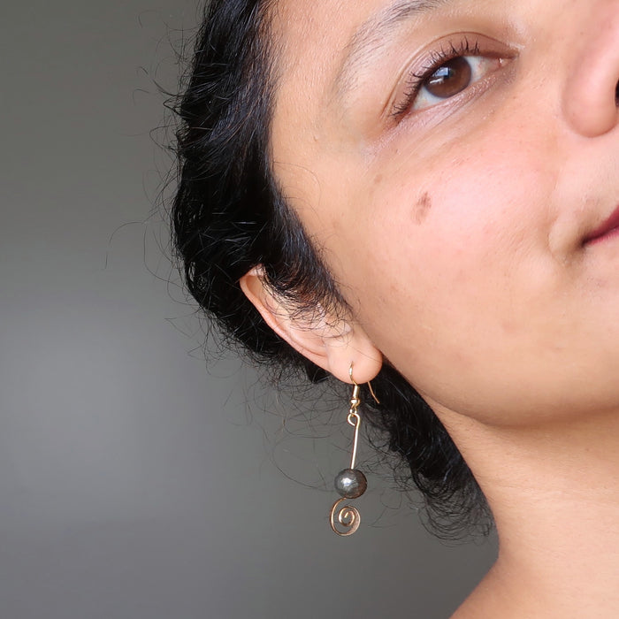 sheila of satin crystals wearing faceted pyrite beads on gold spiral earrings