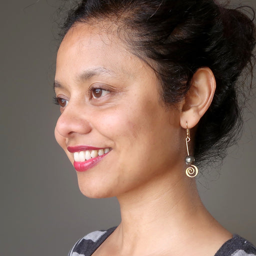 sheila of satin crystals wearing faceted pyrite beads on gold spiral earrings