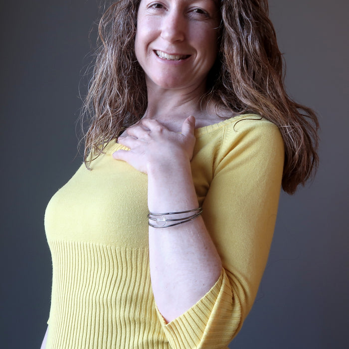 Woman wearing quartz triple coil bracelet and smiling