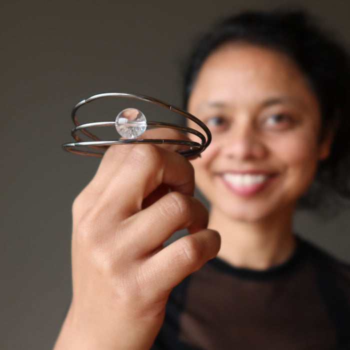 sheila of satin crystals holding a clear quartz wrap bracelet