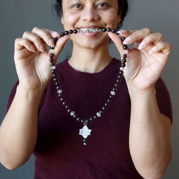 sheila of satin crystals holding clear quartz merkaba pendant on beaded faceted brown chalcedony necklace