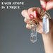 hand holding clear quartz double terminated pendants to show difference