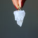 hand holding raw quartz cluster pendant in gold electroplating