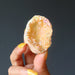 hand holding rainbow aura quartz geode