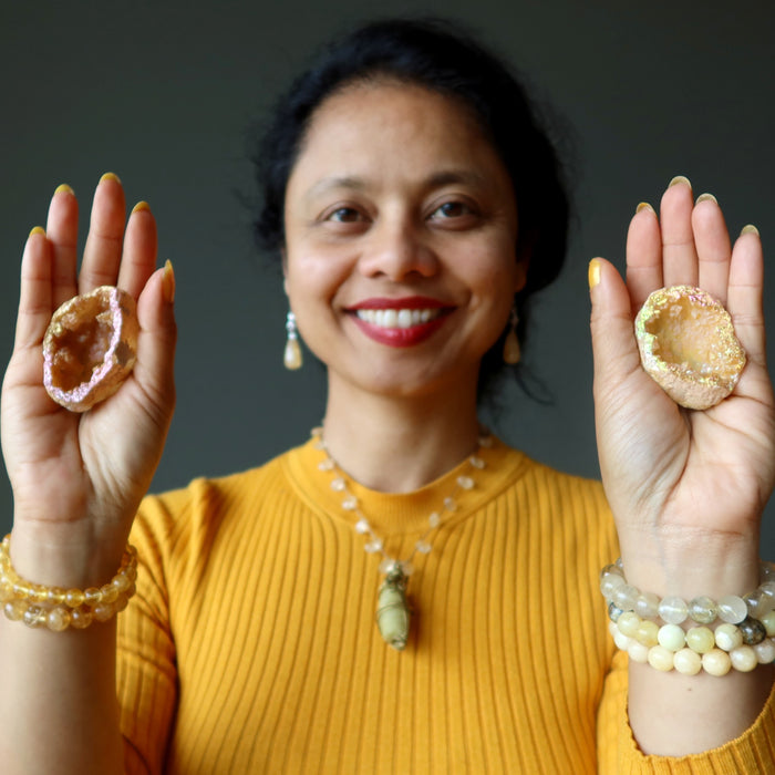 sheila of satin crystals with rainbow aura quartz geodes in each palm