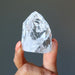 fingers holding Rainbow Crackle Quartz Point Wand Tower