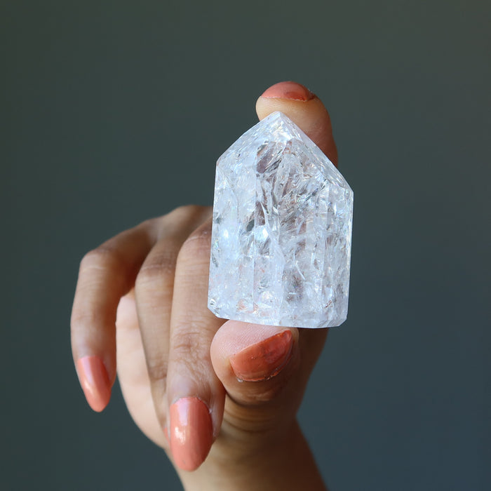 fingers holding Rainbow Crackle Quartz Point Wand Tower