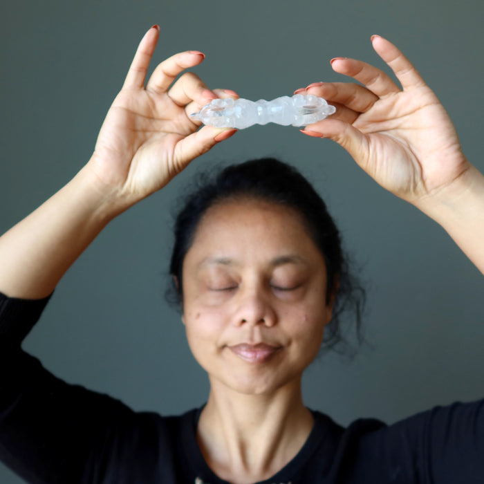 female holding quartz dorje over the head at the crown chakra