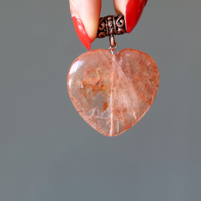 hand holding fire quartz heart pendant 