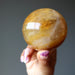 hand holding a golden quartz sphere