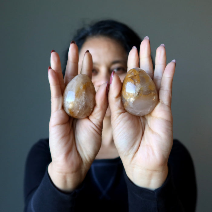 sheila of satin crystals holding two Golden Quartz Eggs one on each hand