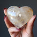 hand holding Golden Milky Hematoid Quartz Heart