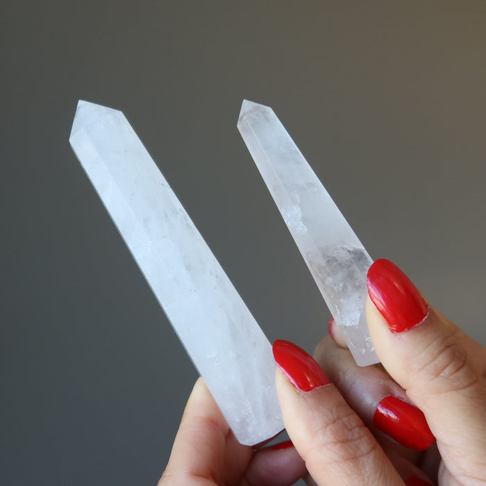 holding two unique faceted Cloud Quartz Wands 