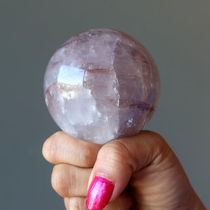 hand holding lavender quartz sphere