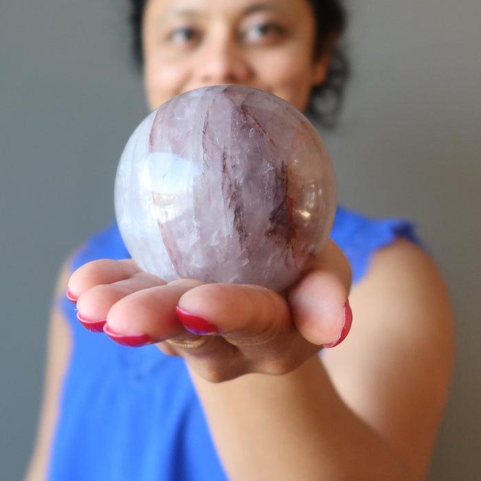 hand holding lavender quartz sphere