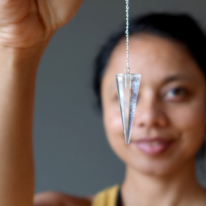 sheila of satin crystals holding a clear quartz pendulum