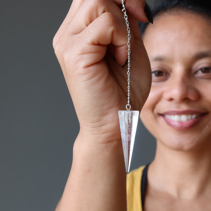 sheila of satin crystals holding a clear quartz pendulum