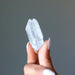 holding one raw clear quartz point