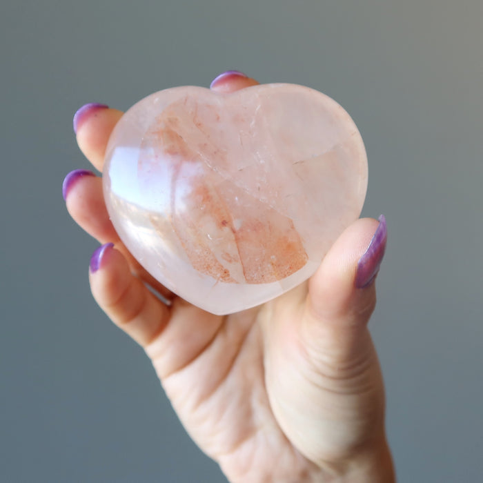 hand holding red fire quartz heart