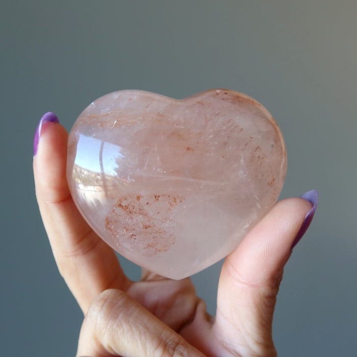 hand holding red fire quartz heart