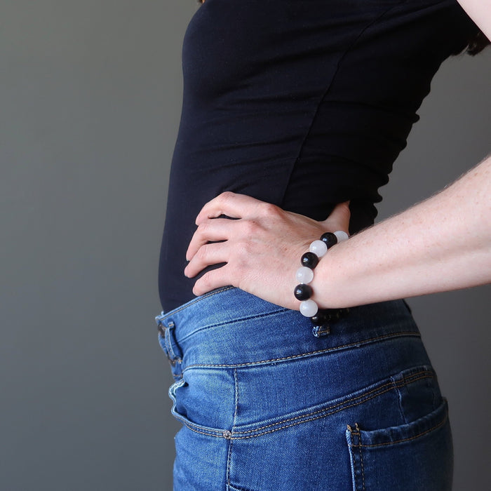 jamie of satin crystals with hand on hip wearing white quartz and black obsidian round beaded stretch bracelet