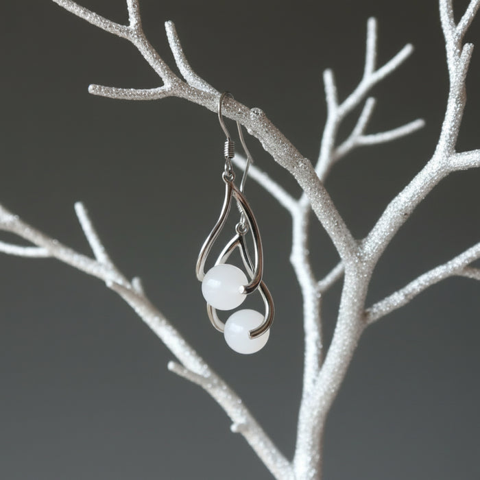 hand holding snow quartz dangle earrings