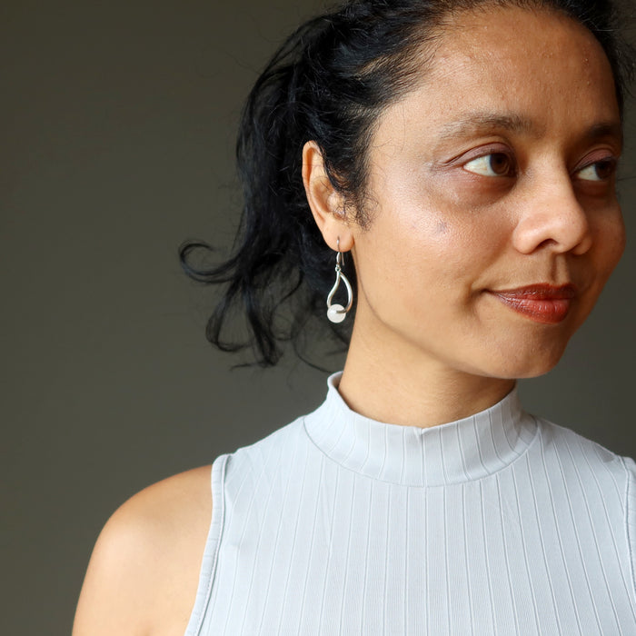 woman modeling snow quartz dangle earrings