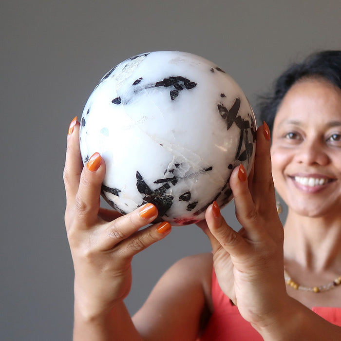 sheila of satin crystals admiring a tourmalinated quartz crystal ball