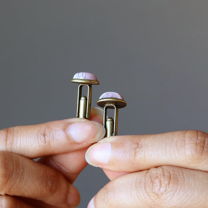 hands holding rhodochrosite cufflinks