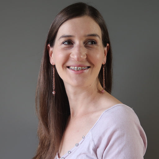 woman wearing rhodochrosite copper dangle earrings