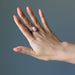 hand wearing pink rhodochrosite oval in gunmetal adjustable ring