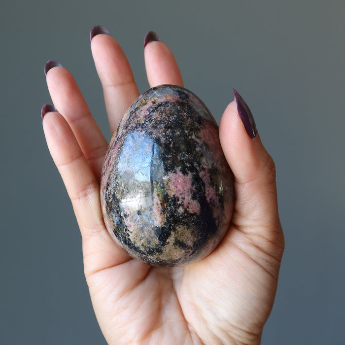 rhodonite egg in hand